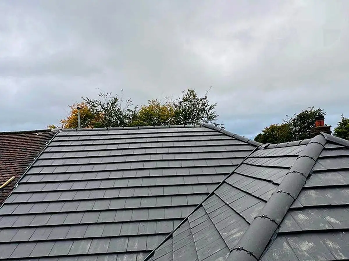Grey concrete tile re-roof with new ridge tiles